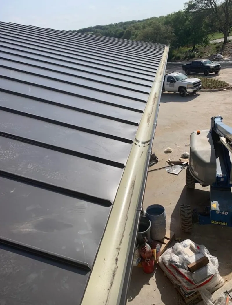 Standing seam panel and gutter detail on a metal roofing jobsite in Ludington